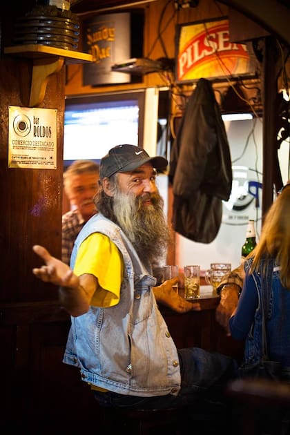 Con una sonrisa un visitante asiduo del Mercado del Puerto nos invita a tomar un medio y medio.