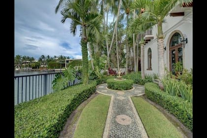 Con vista a un verde jardin cubierto de macetas e infaltables palmeras, incluyendo una fuente.