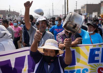 Conductores y residentes protestan en la Autopista Central, donde autobuses y camiones quedaron estacionados para cortar la carretera, en Huaycan, a las afueras de Lima, Perú, el lunes 4 de abril de 2022. 