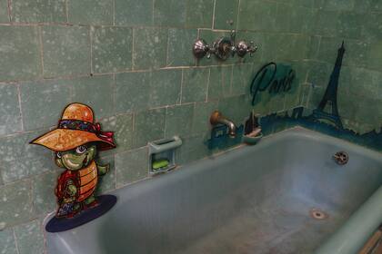 Conectado a todos los espacios de la casa está el baño antiguo, pintado de turquesa y verde con escenas de París, y su personaje más famoso, Manuelita