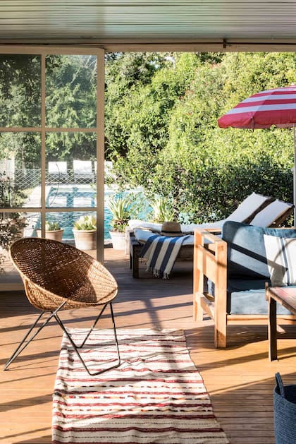 Conectado con la pileta rodeada de reposeras, un lugar de sombra funcional con alma vintage.