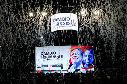 Confeti explota sobre una pantalla que muestra las fotos del candidato Gustavo Petro (izquierda), y de su compañera de fórmula, Francia Márquez, tras su victoria en el balotaje de los comicios presidenciales, en la sede de su campaña, en Bogotá, Colombia, el 19 de junio de 2022. (AP Foto/Fernando Vergara)