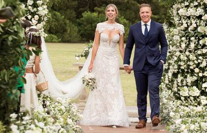 Coni lució un vestido de escote profundo, en tono marfil, diseñado por María Gorof. Realizado en tul francés, estaba bordado con hilos de seda, pequeñas lentejuelas, canutillos y cristales checoslovacos. El velo/capa, con escote bote, también era de tul francés. El traje de novia tenía cosidas (ocultas) una cinta azul, una violeta y otra roja. Ale, el novio, llevó un traje hecho a medida, de Carrington.