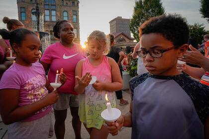 Niños prenden velas en honor a las víctimas de un tiroteo en Ohio