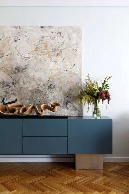 Consola diseñada por el Estudio y hecha a medida, laqueada en azul y con patas de acero inoxidable. La escultura de madera es una creación de Geremias Cesarin. Obra de arte de Sofía Gallo.