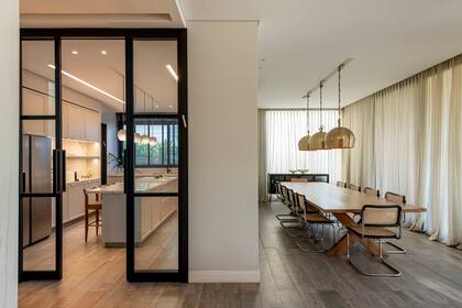 Consola (Landmark), sIllas 'Thonet', mesa de 3,40 x 1,30 metros en petiribi natural, tapa de 2'' pulida y pata en cruz (Métier Studio). Lámparas colgantes de 50 cm diámetro, con detalle de cuerda y nudo.