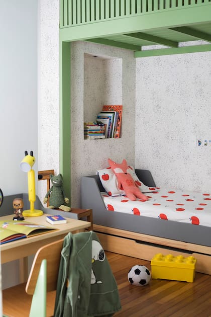 Construido donde originalmente estaba la cocina, en el dormitorio de su hijo se aprovechó cada centímetro. Sobre la cama se construyó un altillo en color verde, su favorito. El empapelado es de Picnic y la cama y escritorio de Ukelele.