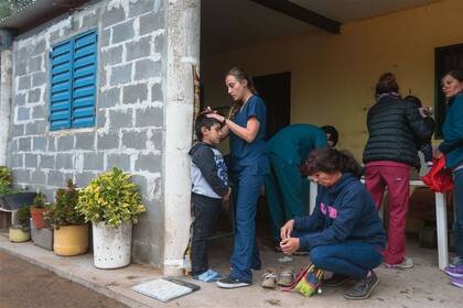  Control de talla. Una de las voluntarias del equipo médico toma las medidas de un niño frente a la casa de María Rodríguez. El problema de la malnutrición se refleja en la altura y el peso de los chicos 