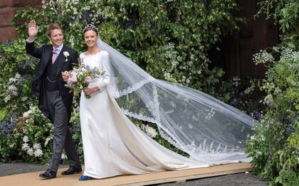 Convertidos en marido y mujer, los duques de Westminster saludan a la gente que se acercó a las inmediaciones de la catedral. Para su gran día, Olivia lució un vestido de la británica Emma Victoria Payne, un diseño en satén de seda color marfil y organza con detalles bordados a mano y cola de dos metros desmontable. El toque azul fueron los zapatos de la firma Silvia Lago, hechos a mano en España. El velo de 1880 era de la tatarabuela de Olivia. El ramo incluía margaritas, iris, rosas, clematis, escabiosas, astrantias y lirios.