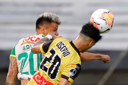 Lucha en las alturas: Walter Bou y Raúl Osorio disputan la pelota; Defensa y Justicia y Coquimbo definirán el sábado, en Florencio Varela, a uno de los finalistas de la Copa Sudamericana