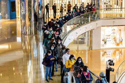 Como en muchas partes del mundo, los habitantes de Hong Kong hace cola para comprar mascarillas y gel desinfectante.
