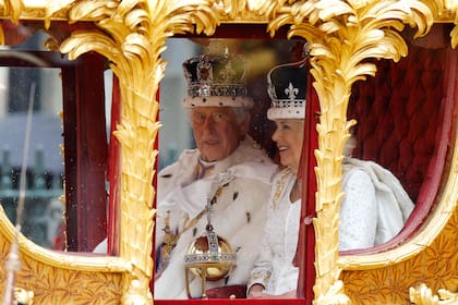 El rey Carlos III de Gran Bretaña y la reina Camilla viajan en el Gold State Coach de regreso al palacio de Buckingham desde la abadía de Westminster, en el centro de Londres, el 6 de mayo de 2023, tras sus coronaciones.