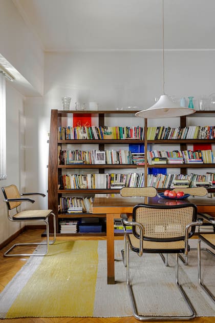 Coronando la estantería 'Thai' (Eugenio Aguirre), una colección de objetos en vidrio heredada. Luminaria colgante en acrílico y alfombra de algodón plano (Graciela Churba).