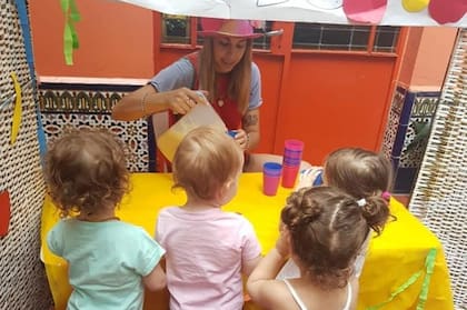 Una imagen de archivo: una maestra maternal y un grupo de nenes, en una escena habitual