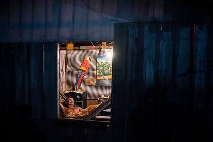 Un hombre descansa en una hamaca dentro de su casa en la comunidad del Parque de las Naciones Indígenas, donde muchos residentes se enfermaron con síntomas del nuevo coronavirus