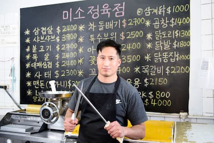 Cortes de carne escritos en coreano en la pizarra de una carnicería