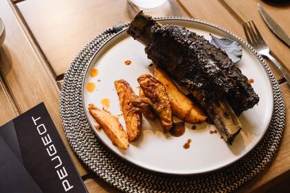 Costilla Estancia Vigil en cocción de 5 horas, gajos de papas y cebollas caramelizadas.