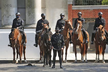 Crimen del policía en Palermo: inhuman en el cementerio de Chacarita los restos de Juan Pablo Roldán. Uno de los efectivos sostiene de las riendas a "Místico", el caballo de Roldán