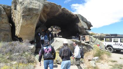 Cristian Gerónimo dirige a su grupo de turistas al interior de la cueva donde el almuerzo de estofado de guanaco los esperando