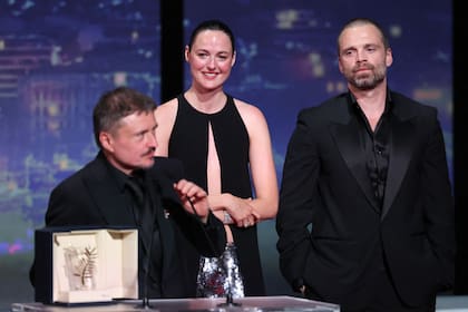 Cristian Mungiu agradece la Palma de Oro; a su lado, Renate Reinsve y Sebastian Stan