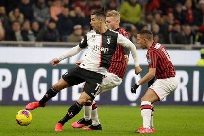 Cristiano Ronaldo lleva la pelota ante la marca de dos jugadores de Milan