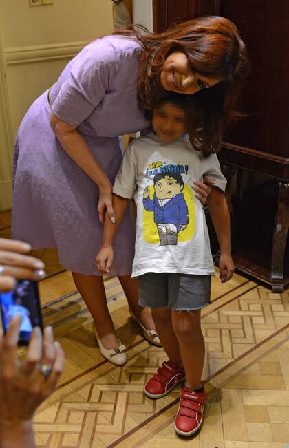 Cristina Kirchner durante un acto en la Casa Rosada,  junto a una nena que usa una remera inspirada en La asombrosa excursión de Zamba