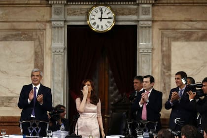 Cristina Kirchner saludando con un beso junto a Julián Dominguez (iz), presidente de la Cámara de Diputados, y Gerardo Zamora (de), presidente provisional del Senado