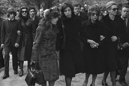 Cristina Onassis en el funeral de su padre, Aristóteles Onassis, en la isla de Skorpios. En segunda fila aparece la viuda, Jacqueline Kennedy Onassis, quien camina tomada del brazo de su hijo, John F. Kennedy Jr. | Location: Skorpios, Greece.