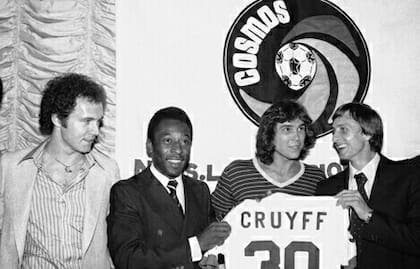 Beckembauer y Pelé le dan la bienvenida a Cruyff, que posa con la camiseta N° 30 del Cosmos, junto con Werner Roth, que actuó en la película "Escape a la victoria"; el holandés jugó en la NASL en otros equipos, pero se sumó al equipo de NY en un amistoso ante "World All Stars" en