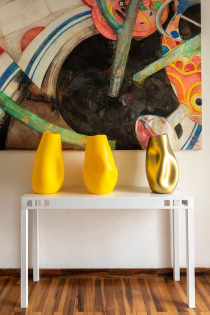 Cuadro pintado por Manghi y tres de sus piezas pintadas en dorado mate y amarillo cadmio en el recibidor de entrada. "Al pintarlas, se acentúan sus formas pero pierden la transparencia propia del vidrio".