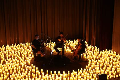 Cuarteto de cuerdas en un show que se realiza solo con iluminación de velas, en el auditorio del Colegio San José.