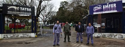 Cuatro de los delegados de Emfer y Tatsa, en la entrada que la fábrica tiene en Savio