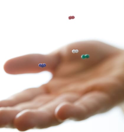 Cuatro grupos de partículas milimétricas son levitadas encima de una mano