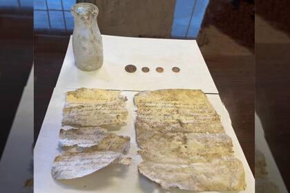 Cuatro monedas y dos cartas: el hallazgo inesperado adentro de una botella que data de más de un siglo