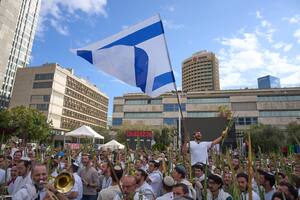 Cubiertos con chales de oración, hombres bailan y sostienen los cuatro símbolos de la festividad judía de Sucot, en la Plaza de los Rehenes.