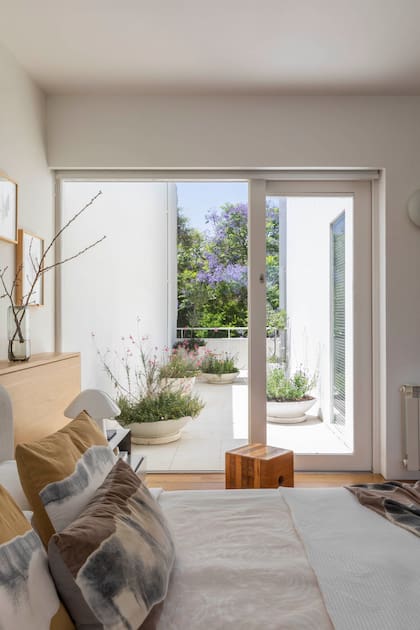 Cubo de madera maciza (Victoria d’Ornellas). Pie de cama y almohadones (Pezkoi).