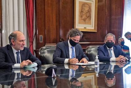 El jefe de Gabinete, Santiago Cafiero, junto al titular del Banco Nación, Eduardo Hecker, y el jefe de la Asociación Bancaria, Sergio Palazzo.