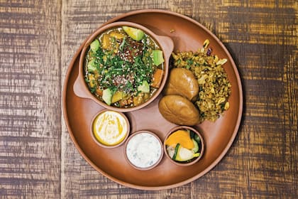 Curry de verduras con tofu laqueado en salsa teriyaki y palta, con dips de salsas picantes y pickles.