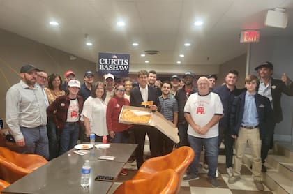 Curtis Bashaw junto a su equipo de voluntarios comiendo pizza luego del incidente que vivió en el debate