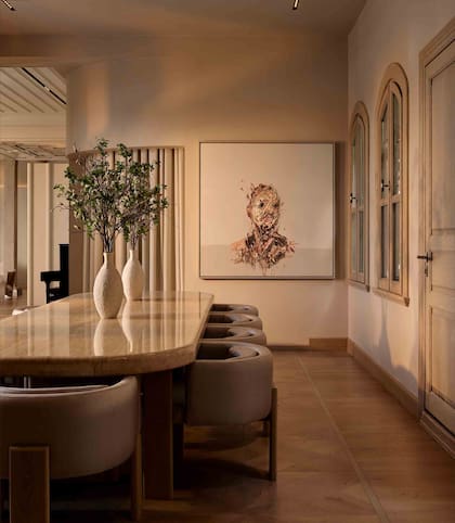 Curvas suaves, iluminación empotrada y una paleta de colores orgánica marcan las decisiones de diseño. En el comedor, una gran mesa de piedra se convierte en protagonista.