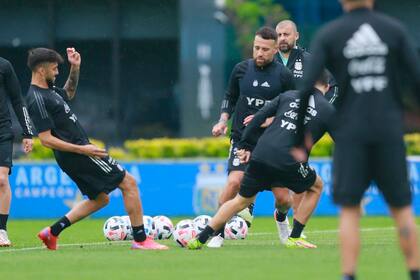 Cuti Romero y Otamendi traban, bajo la mirada de Walter Samuel, uno de los asistentes de Scaloni