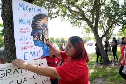 - Cynthia Moreno, de 32 años, coloca un cartel frente a una oficina de la agencia policial de inmigración (AP Foto/Lynne Sladky, File)
