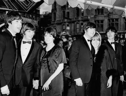 Cynthia vivió los primeros años de éxito de The Beatles. En la imagen, de izquierda a derecha: Paul McCartney, Ringo Starr con su mujer Maureen, John Lennon y Cynthia Powell, y George Harrison. La fotografía fue tomada durante la premiere del fil "Help", en de julio de 1965 (Photo by Daily Express/Archive Photos/Getty Images).