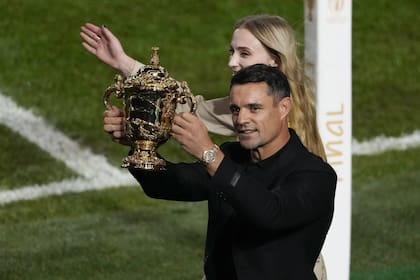 Dan Carter sostiene la Copa Webb Ellis junto a Sophie Turner luego de la final del Mundial de Rugby