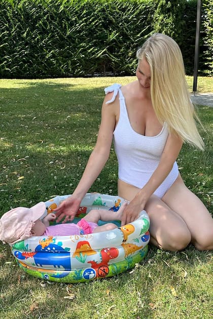 Daniela Christiansson refresca a la pequeña Elle en una pileta, en un parque de Ginebra, Suiza