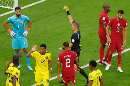 Daniele Orsato, árbitro italiano, le muestra la tarjeta amarilla al arquero de Qatar, Saad Al Sheeb; en el Mundial, cada dos tarjetas amarillas un jugador recibirá un partido de suspensión
