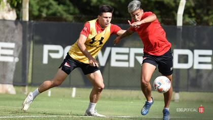 Darío Sarmiento (derecha) en un entrenamiento con Estudiantes, en City Bell, tratando de dejar en el camino a Castro