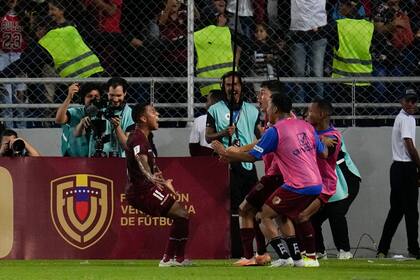 Darwin Machis festeja con sus compañeros tras anotar ante Chile en un encuentro de las eliminatorias, en Maturín