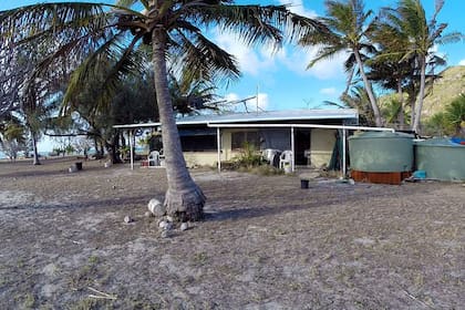 Una foto de la casa de Glasheen en la isla, completa con dos contenedores de almacenamiento que recogen la lluvia para el agua potable.
