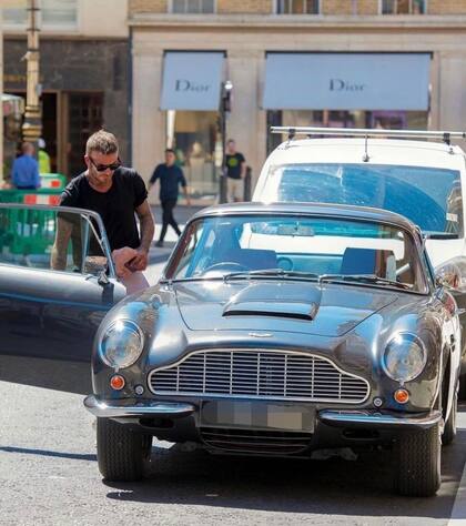 David Beckham disfrutando del sol en su Aston Martin DB6 de 1965 en Mayfair, Londres.